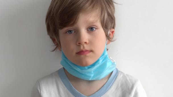 ochrona przed koronawirusem. mały chłopiec nakłada maskę na jej twarz. - Materiał filmowy, wideo