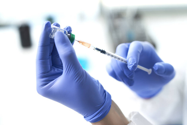 Seringa e vacina nas mãos de um médico
 - Foto, Imagem