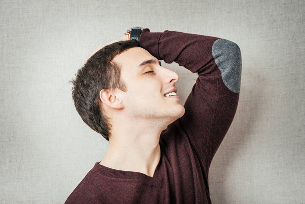 Крупним планом портрет засмученого молодого чоловіка з рукою на голові
 - Фото, зображення