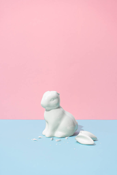 Easter bunny with broken ears. Minimal pastel pink and blue Easter holiday concept. Contemporary style. - Fotó, kép
