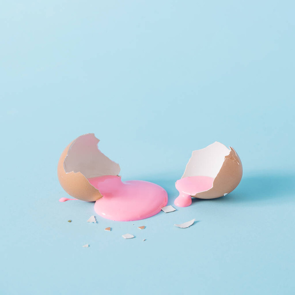 Casca de ovo com tinta rosa pastel. Espaço de cópia criativa no fundo azul. Conceito mínimo de férias de Páscoa
. - Foto, Imagem