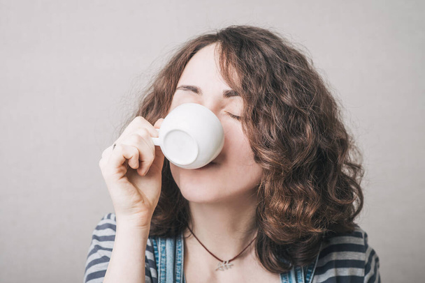 girl drinking coffee, dressed in overalls - Foto, Bild