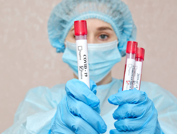 Nurse holding test tube with blood for 2019-nCoV analyzing. Coronavirus positive blood test concept - Valokuva, kuva