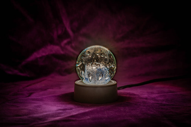 Close up of an Illuminated crystal ball with velvet background - Foto, imagen