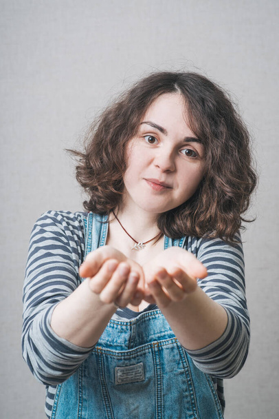 girl holding something in her hands, wearing a jumpsuit - Foto, Imagem