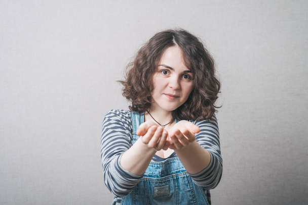 girl holding something in her hands, wearing a jumpsuit - Fotoğraf, Görsel