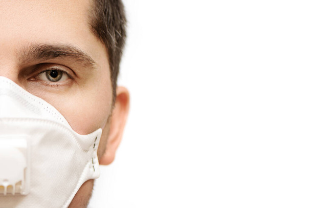Partial view of young man in protective medical mask on white background. - Foto, Bild