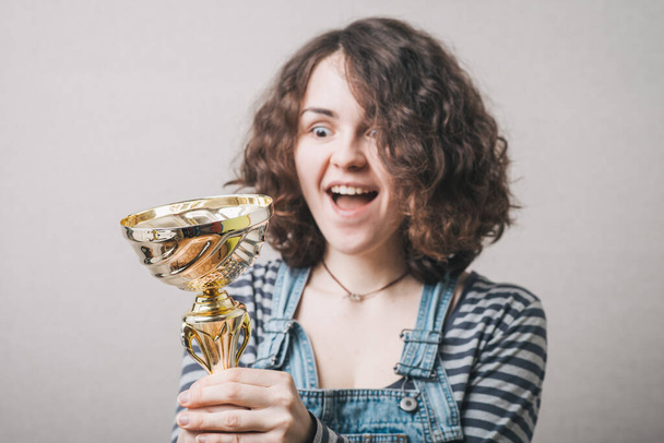 Nuori tyttö tilalla palkinnon cup ja onnellinen
 - Valokuva, kuva