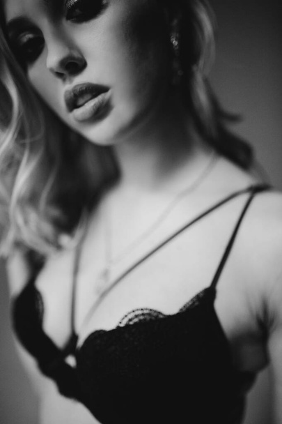 Blurred monochrome studio side portrait of young woman in black lingerie. Blur photo - Foto, Imagen