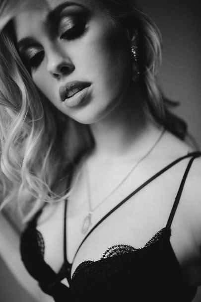 Monochrome studio portrait of young woman in black lingerie - Foto, Imagen