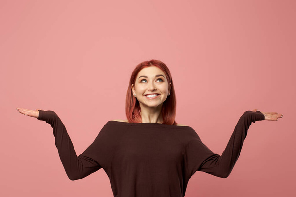 Smiling ginger woman with gray eyes with hands up - Photo, image