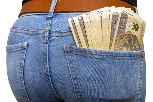 Beaucoup de billets polonais d'une valeur nominale de 200 PLN insérés dans la poche arrière des pantalons en denim bleu femme, isolés sur un fond blanc avec un chemin de coupure
. - Photo, image