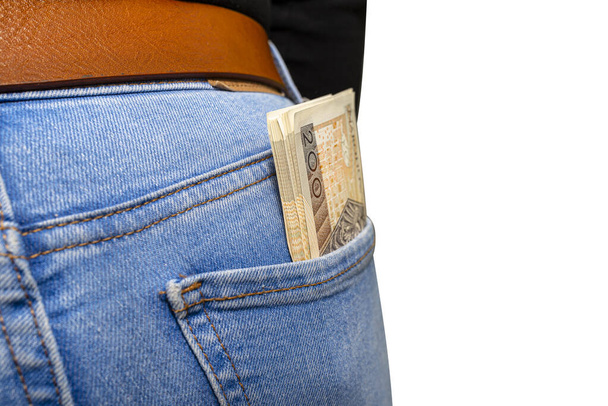 Un sacco di banconote polacche con un valore nominale di 200 PLN inserite nella tasca posteriore delle donne pantaloni di denim blu, isolate su uno sfondo bianco con un percorso di ritaglio
. - Foto, immagini