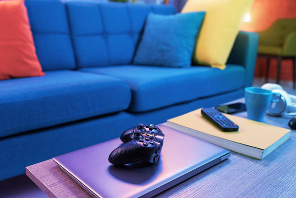 Colorful living room interior with couch, video game controller in the foreground - Fotoğraf, Görsel