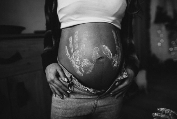 nő terhes has gyermek ujjlenyomatok ing és kék farmer - Fotó, kép