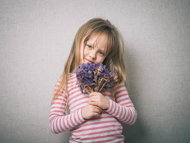 little girl with a bouquet of flowers in the studio - Foto, Bild