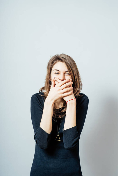 A young woman holding back vulgar jokes - Foto, afbeelding