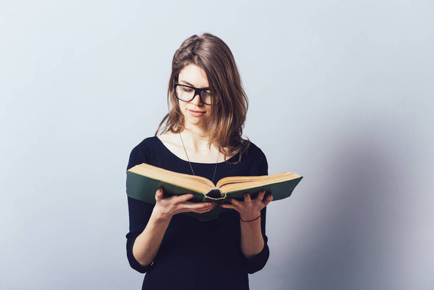 Girl with glasses reading a book - Фото, зображення