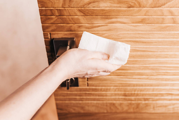 To protect against coronavirus, wipes the door handles in the office and at home with a napkin - sanitization with an alcohol antiseptic - Valokuva, kuva