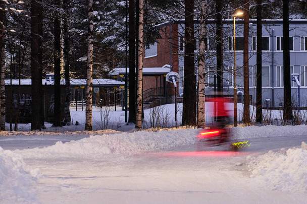 冬の街、雪に覆われた木々、運動中のサイクリスト、フィンランドのJoensuu. - 写真・画像