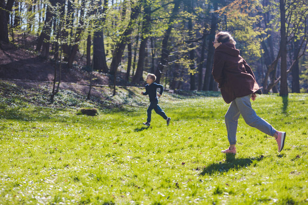 matka se synem běží na jaře slunný park kopírovat prostor - Fotografie, Obrázek
