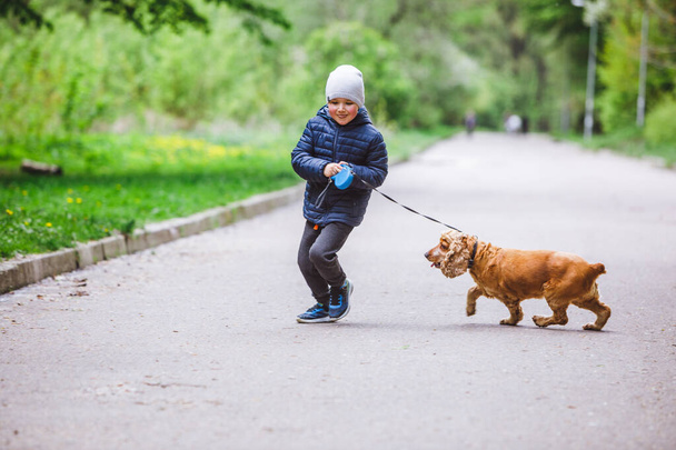 little kid with small brown dog running in city park copy space - Photo, Image
