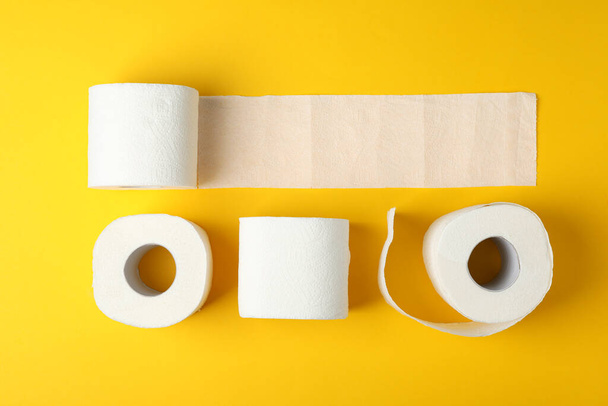 Płaska leżanka z papierem toaletowym na żółtym tle, widok z góry - Zdjęcie, obraz