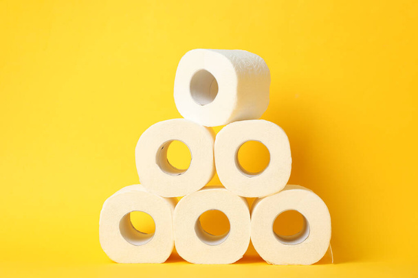 Rolos de papel higiênico sobre fundo amarelo
 - Foto, Imagem