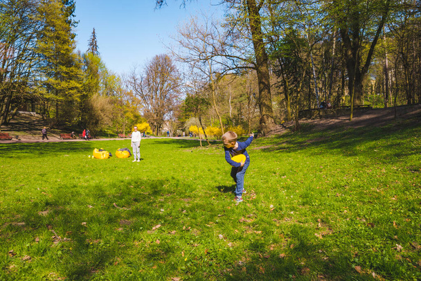 madre con sol jugando frisbee en primavera soleado parque copia espacio
 - Foto, imagen
