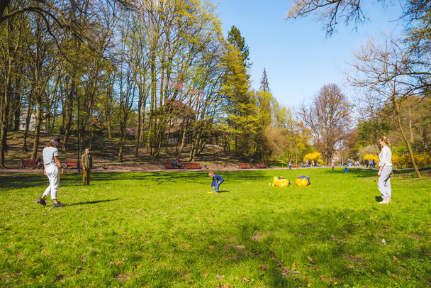 Freunde spielen Frisbee an sonnigem Frühlingstag im öffentlichen Park - Foto, Bild
