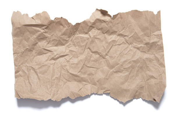 Фрагмент коричневой бумаги с разорванными краями и крошечными следами. Объект на белом фоне с тенью
. - Фото, изображение