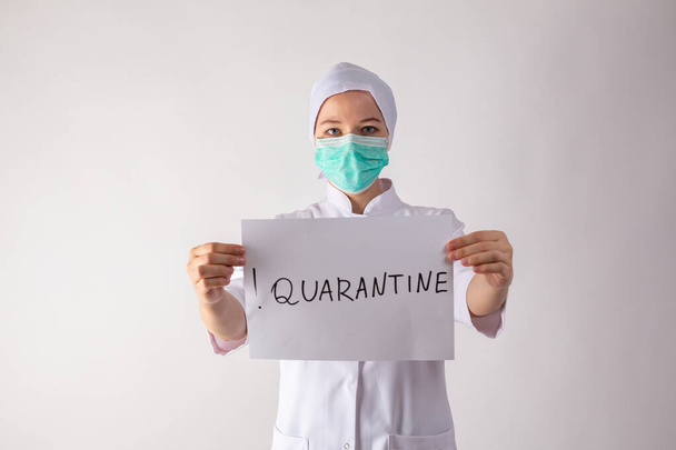Girl doctor holds a quarantine sign in his hands - Foto, Imagem