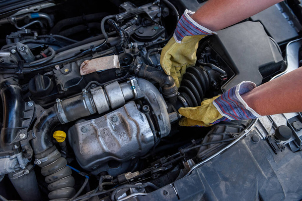 Mechanic examining car engine under hood close up - Photo, Image