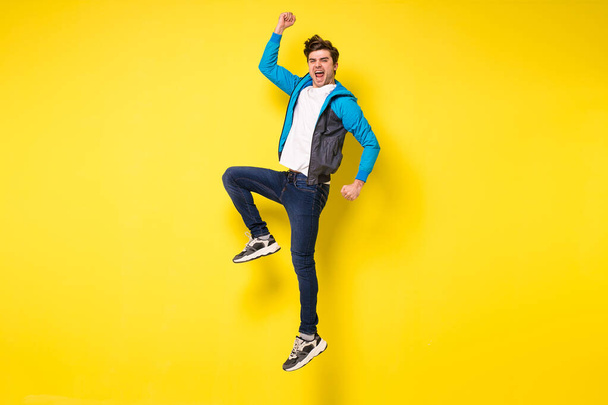Mid-air shot of handsome young man jumping and gesturing, showing excitment - Foto, Bild