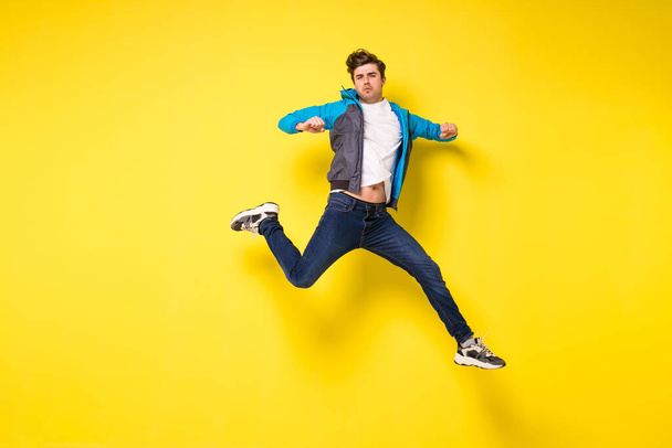 Mid-air shot of handsome young man jumping and gesturing, showing excitment - Foto, immagini