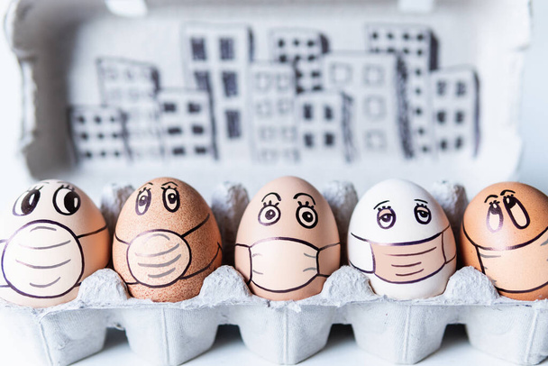 Různorodá kuřecí vejce s čmáranicemi na obličeji v lékařských maskách s panorama města na pozadí. Koncepční obraz znečištění a epidemie - Fotografie, Obrázek