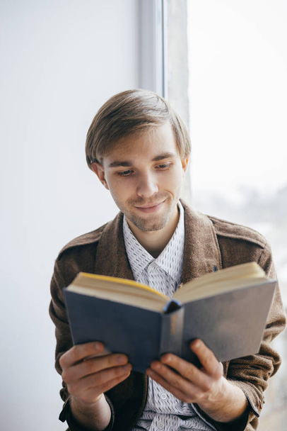 Young man reading a book - Фото, изображение