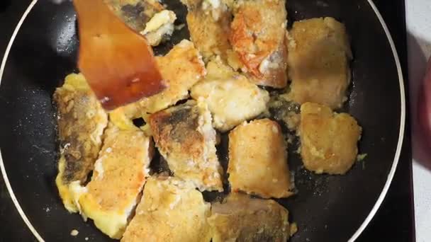 gebakken vis van dichtbij op een pan in broodkruimels in meel. selectieve focus. - Video