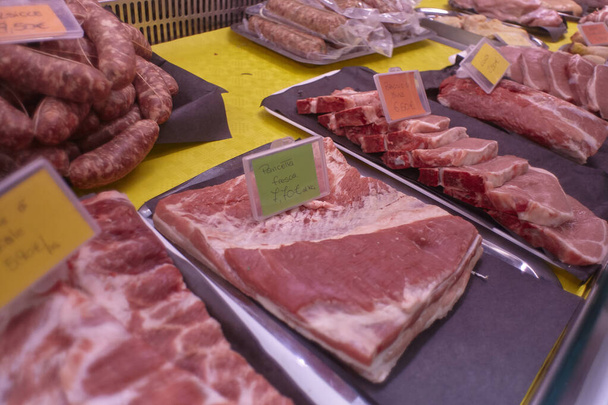 Varios cortes de carne expuestos en el mostrador de la nevera de la carnicería
 - Foto, Imagen