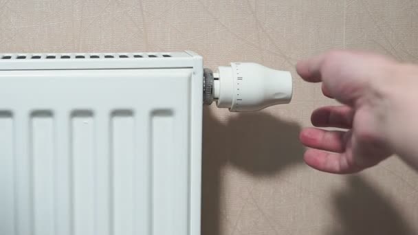 man hand adjusting temperature thermostat on radiator. - 映像、動画