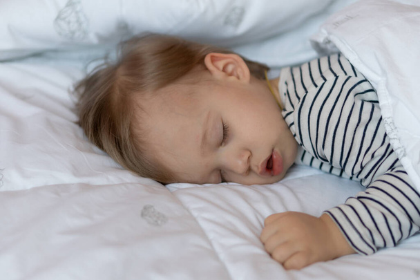 Little blond baby is sleeping in his bed - Fotografie, Obrázek