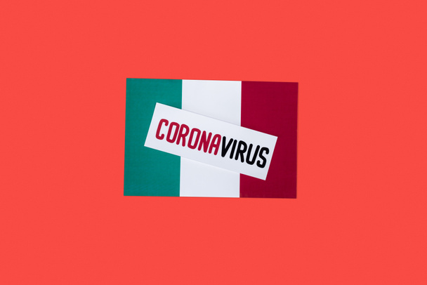 top view of italian flag with coronavirus lettering isolated on red  - Foto, afbeelding