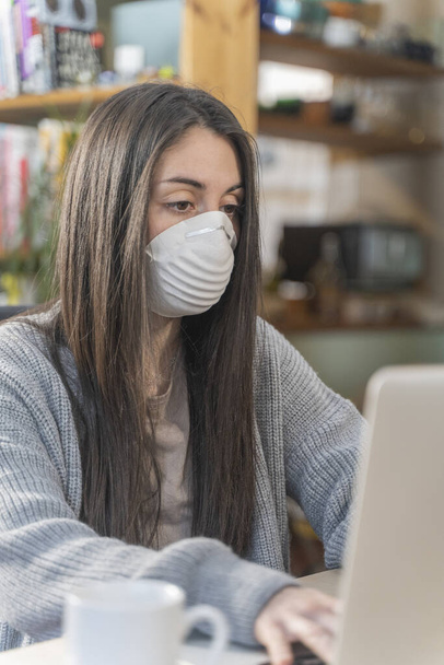 Coronavirus. Business woman working from home wearing protective mask. Business woman in quarantine for coronavirus wearing protective mask. Working from home.  Cleaning her hands with sanitizer gel.  - Foto, Imagem