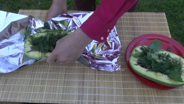 halbe Zucchini mit Gewürzkräutern in Alufolie gewickelt zum Kochen - Filmmaterial, Video
