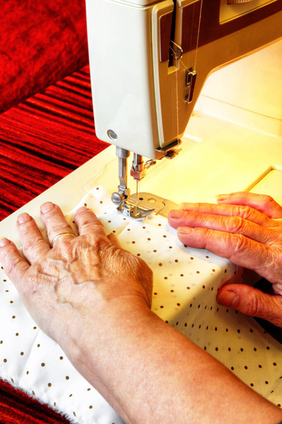 Uma mulher que trabalha com uma máquina de costura moderna vista de perto
 - Foto, Imagem