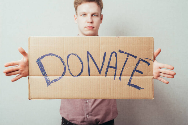 man shows a poster donate - 写真・画像