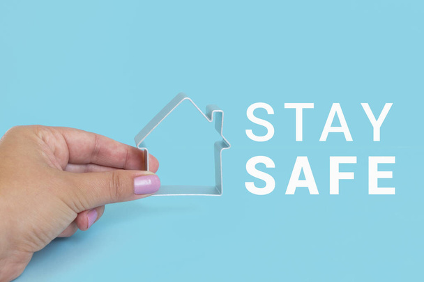 STAY SAFE mit Hausfingern auf blauem Hintergrund. Motivationsbanner für die Selbstisolation während der Coronavirus-Pandemie covid-19 - Foto, Bild