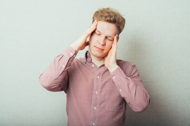 A young man having a headache - Фото, зображення