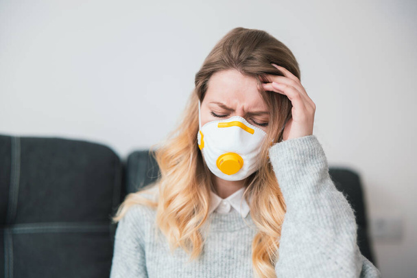 fiatal szőke nő visel orvosi védelmi maszk ül elszigetelt otthon karantén alatt úgy néz ki, beteg, vírus járvány koncepció. - Fotó, kép