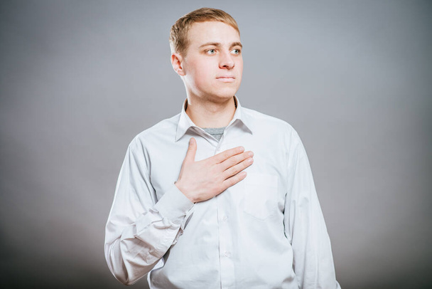 Young businessman is swearing allegiance with his hand on his chest - Foto, immagini
